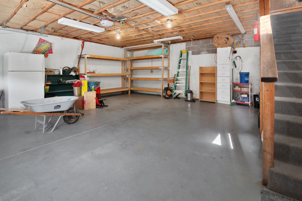 creative Spacious garage interior with storage shelves, tools, and a wheelbarrow, ideal for home organization.